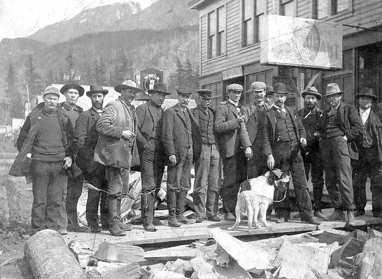 กลุ่มของ Soapy Smith ยืนอยู่ด้านนอกร้านอาหาร Skagway, Alaska, ประมาณปี 1897 By KUBET